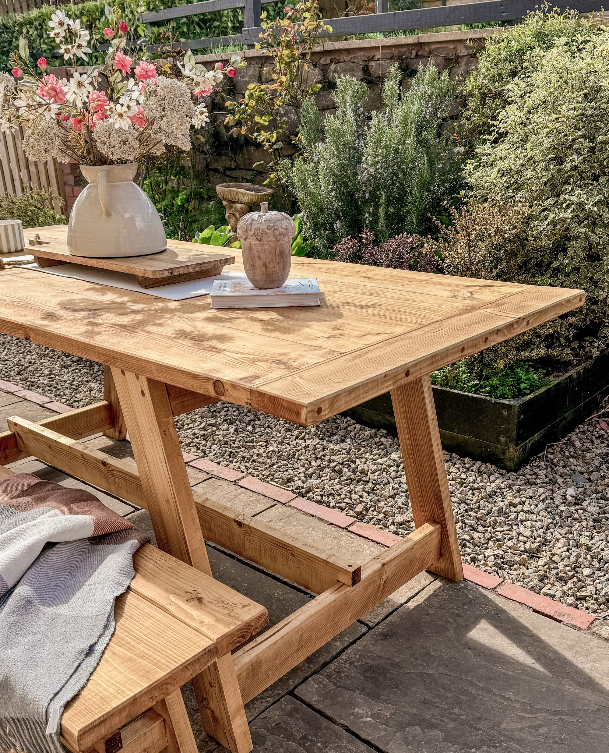 Wooden outdoor table with benches in a garden setting