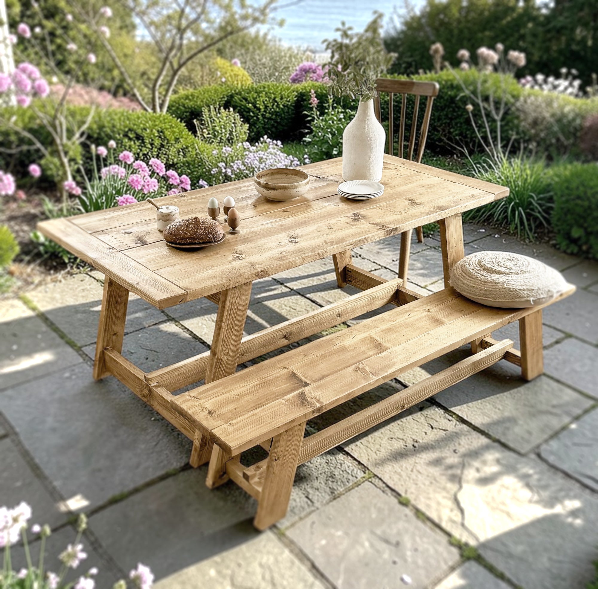 Wooden outdoor table and bench set with decorative items on a patio