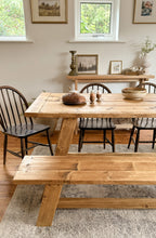 Close up of the end of the farmhouse dining table with bench, showing how to style with chairs and a narrow console table.