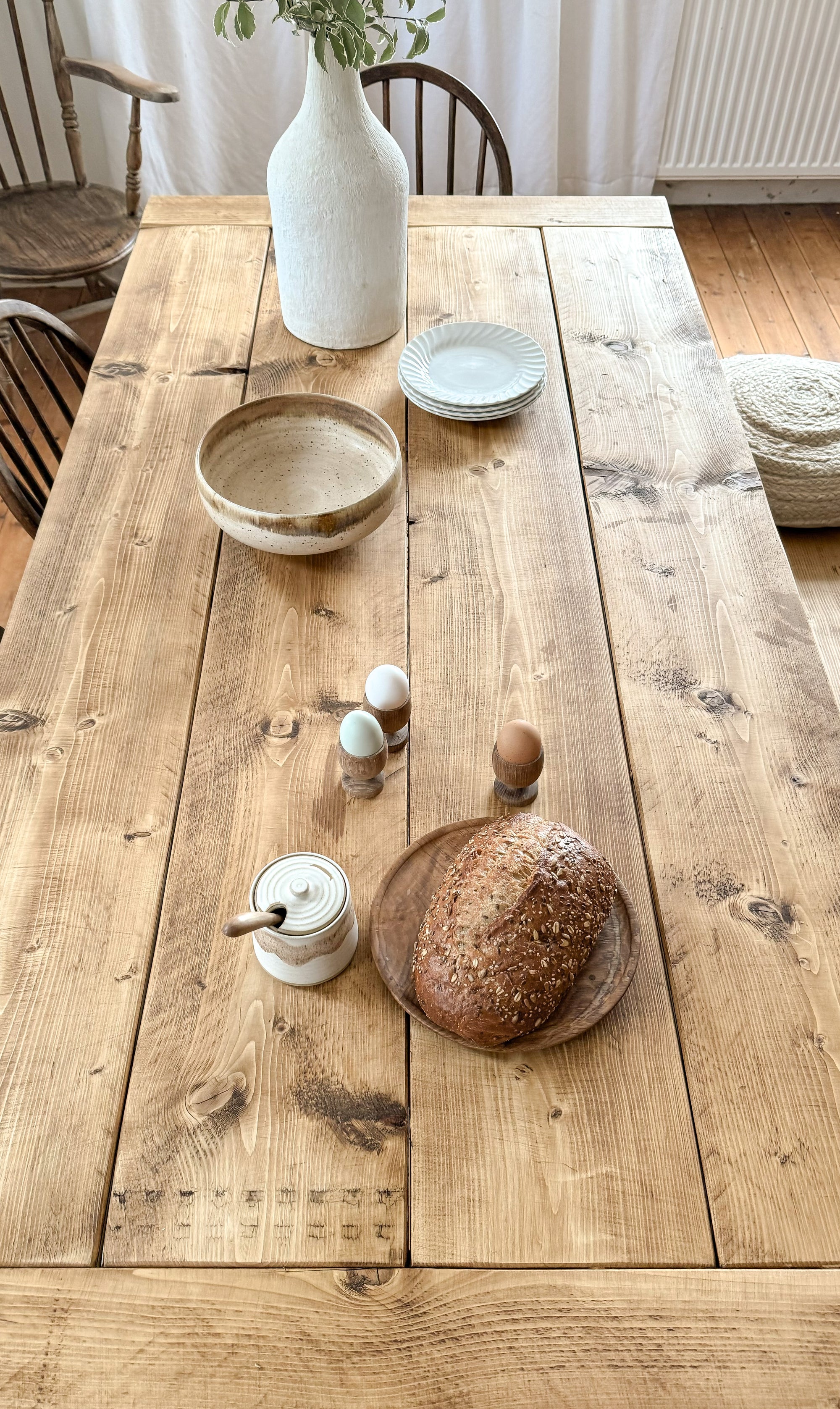 Top down view of dining table top, showing relciamed wood character.