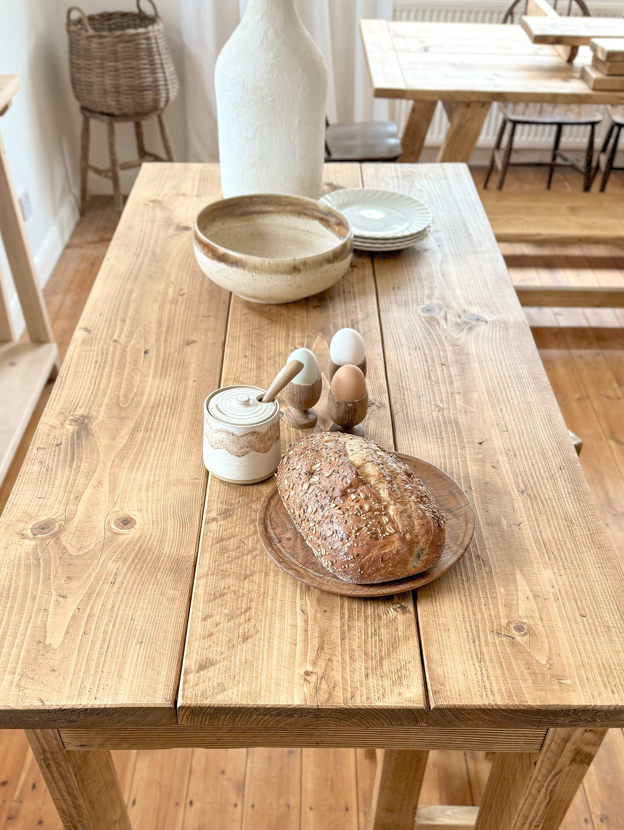 kitchen bar table with bread, a jar, and a vase in a room setting.