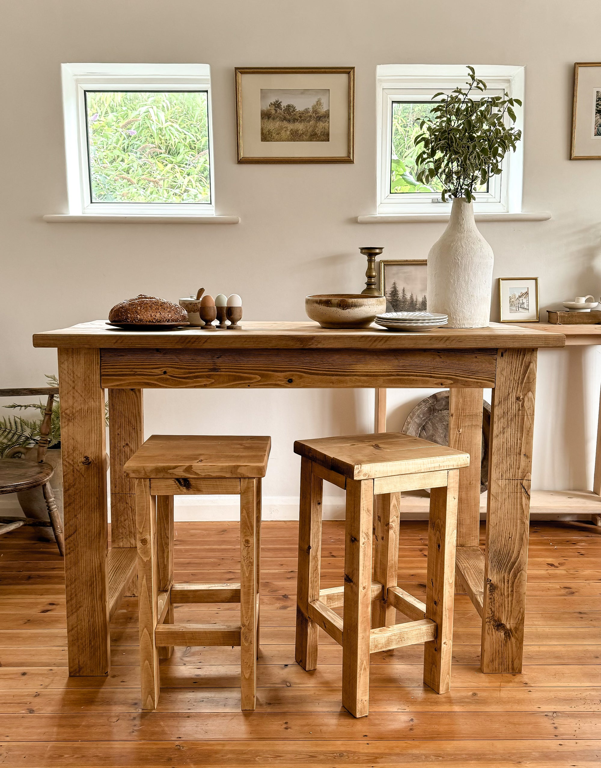 bar table for breakfast in antique oak finish with 2 stools, with a white wall on a wooden floor