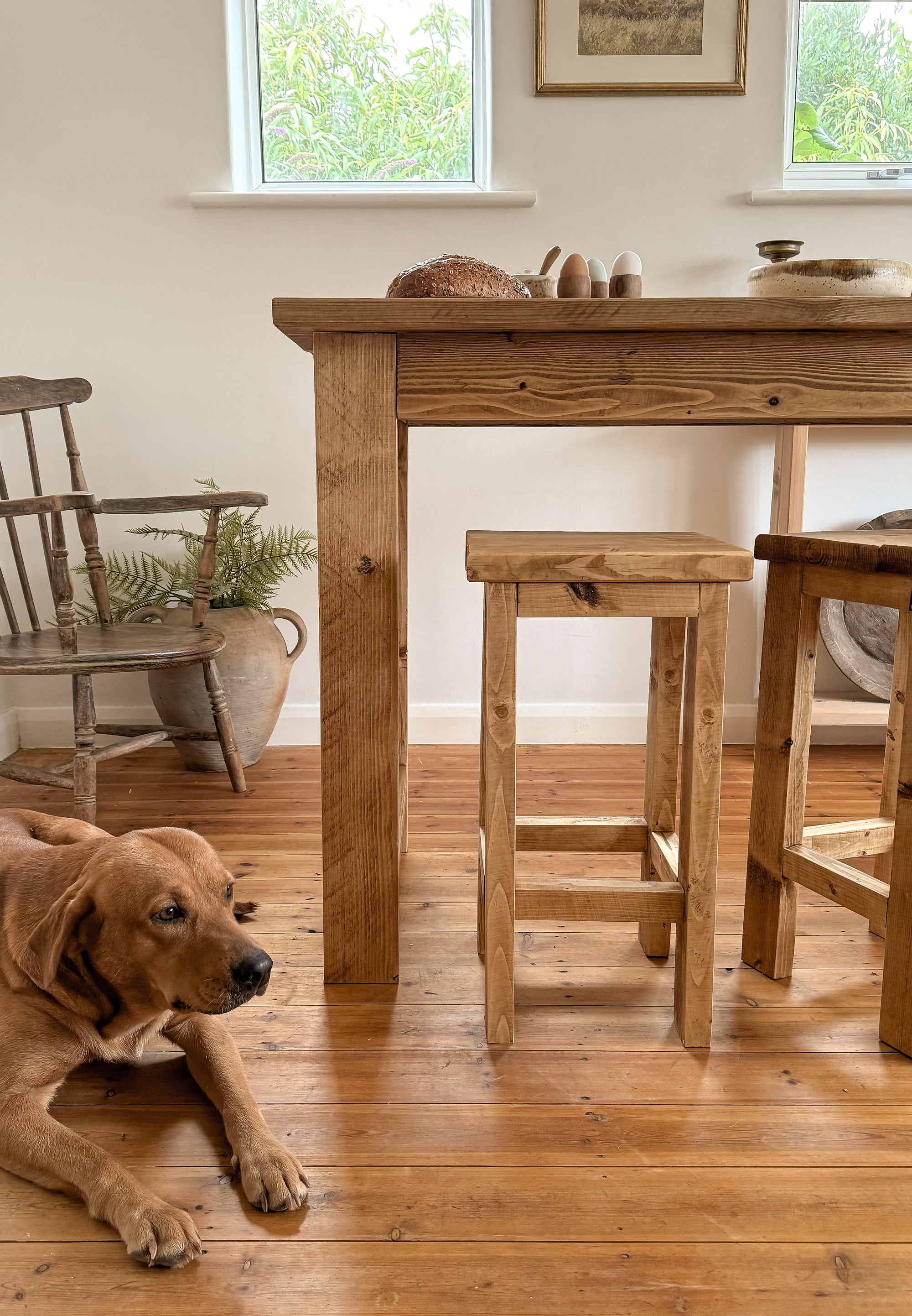 wooden bar table with fox red labrador next to it