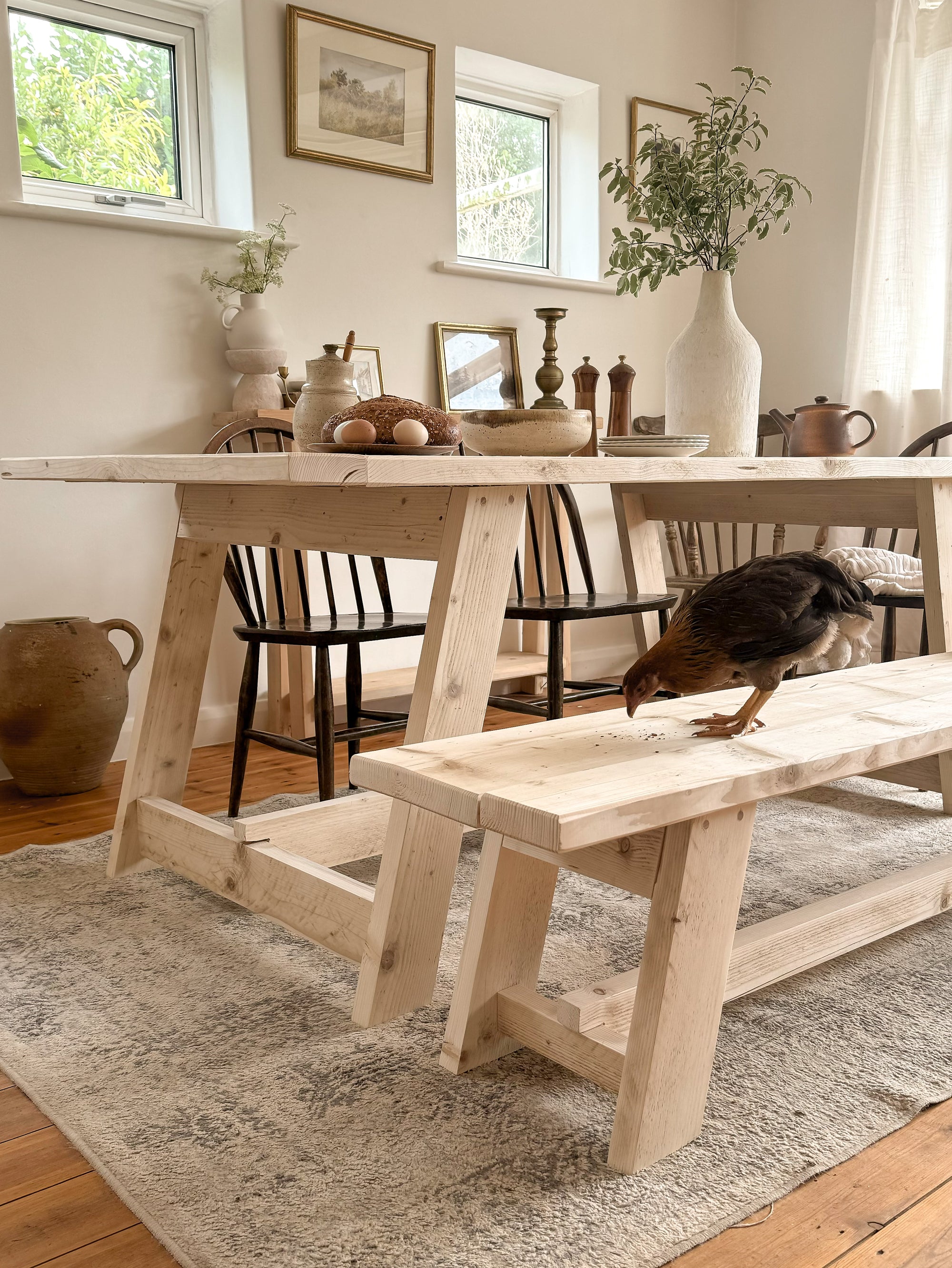 Sturdy wooden dining table legs and end frame design in reclaimed wood with chicken standing on bench
